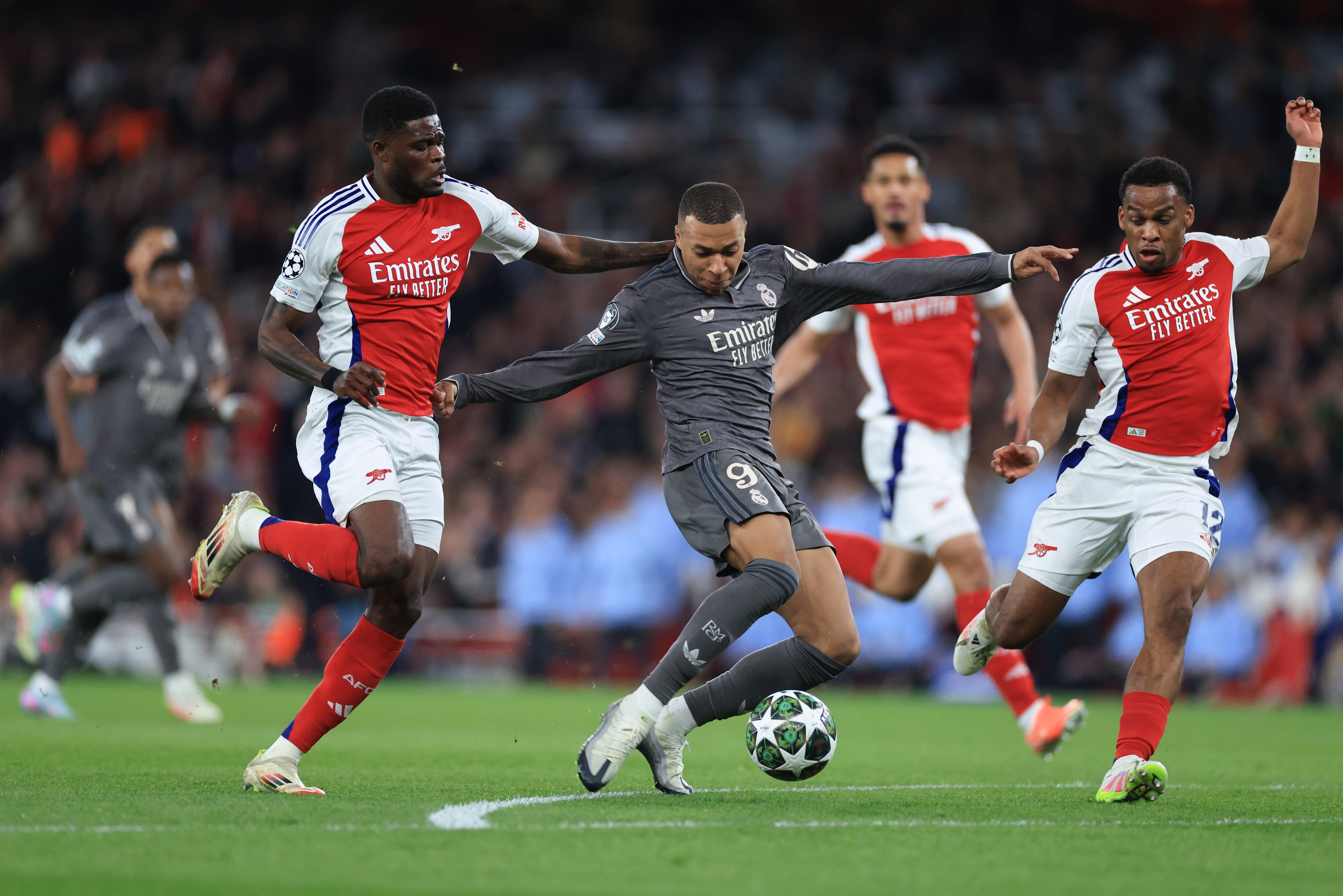 LONDON, ENGLAND - APRIL 08: Kylian Mbappe of Real Madrid runs with the ball under pressure from Thomas Partey and Jurrien Timber of Arsenal during the UEFA Champions League 2024/25 Quarter Final First Leg match between Arsenal FC and Real Madrid C.F. at Arsenal Stadium on April 08, 2025 in London, England. (Photo by Marc Atkins/Getty Images)