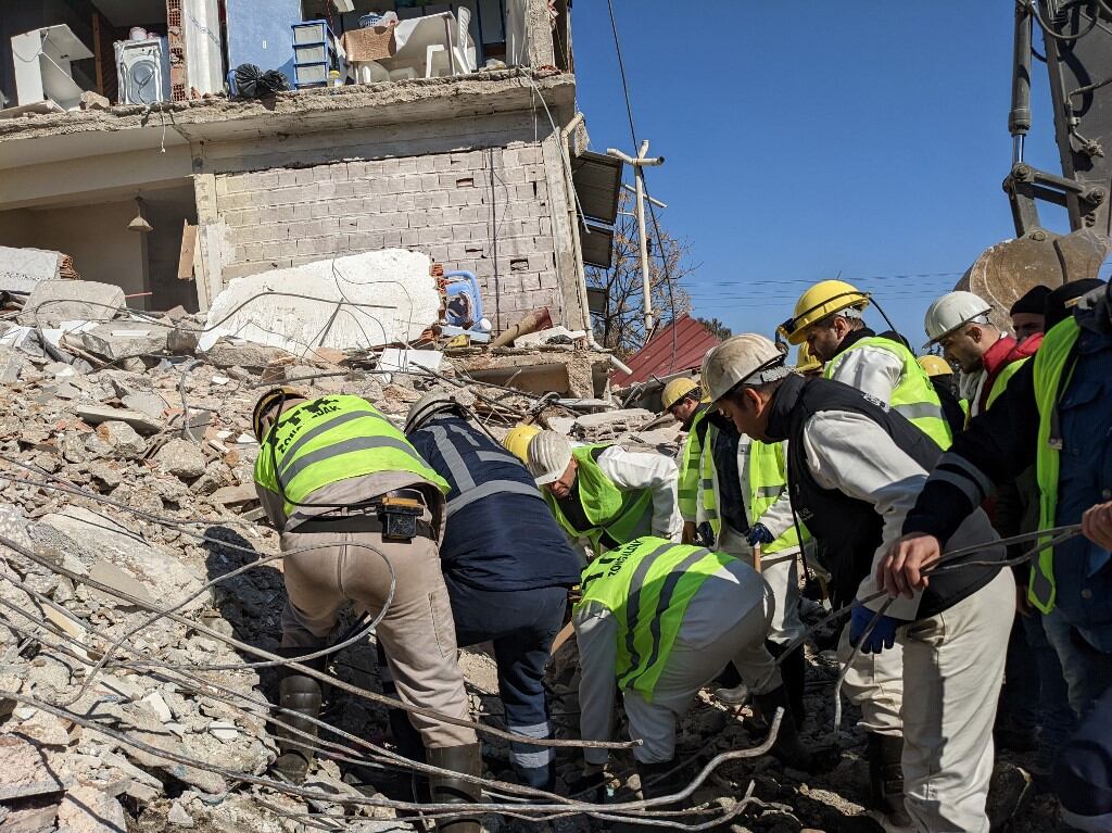 Los mineros de Turkish Hard Coal Enterprises (TTK) de Zonguldak trabajan para retirar los escombros para extraer el cuerpo de un niño mientras realizan operaciones de búsqueda en Antakya, el 9 de febrero de 2023, tres días después de que un terremoto de magnitud 7,8 azotara el sureste de Turquía. - Un grupo de mineros de TTK de la ciudad de Zonguldak, en el norte de Turquía, llegó a la provincia suroriental de Hatay el 8 de febrero para ayudar en las búsquedas tras uno de los temblores más mortíferos en décadas. El número de muertos por un gran terremoto que azotó Turquía y Siria subió a más de 17.100 el 9 de febrero, cuando se desvanecieron las esperanzas de encontrar sobrevivientes atrapados bajo los escombros en un clima helado. (Foto de Remi BANET / AFP)