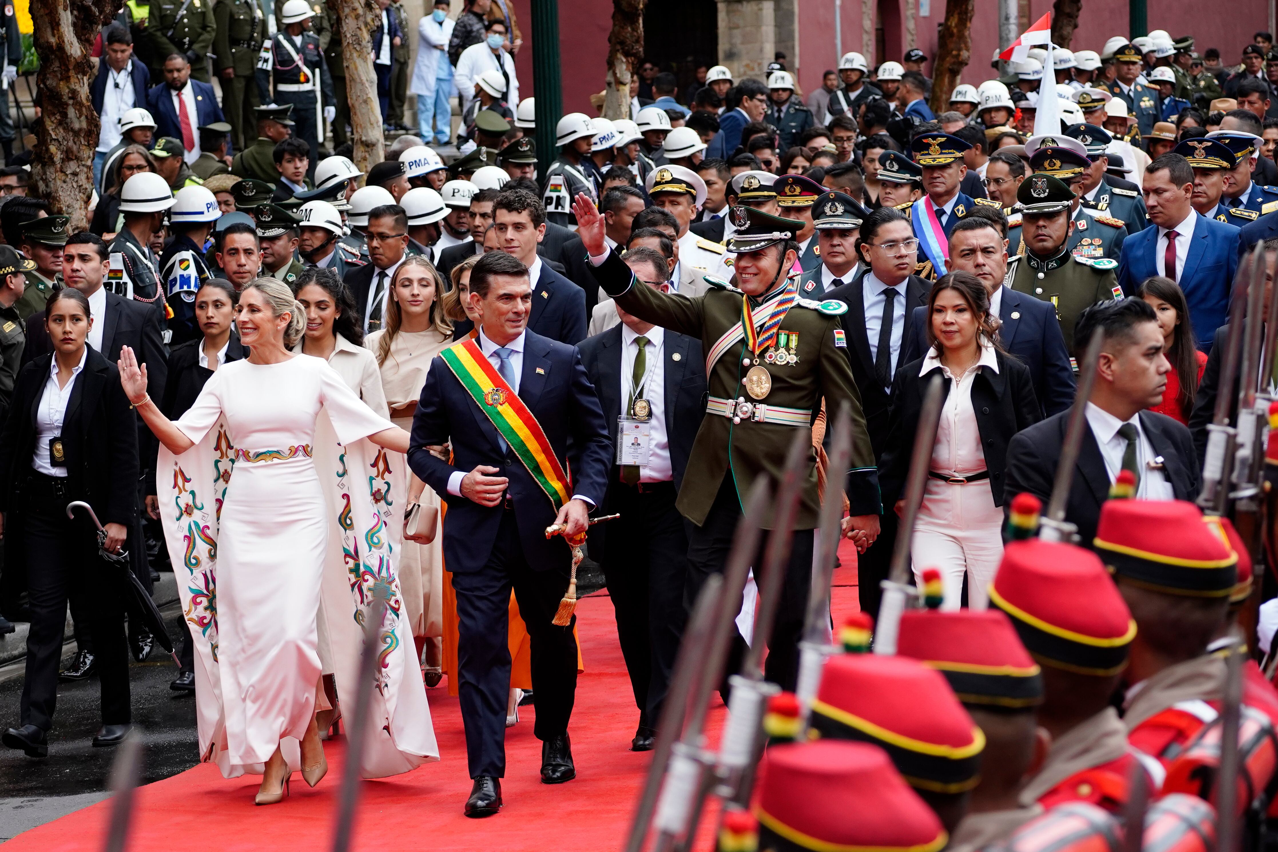 El presidente Rodrigo Paz, segundo por la izquierda, su esposa María Elena Urquidi, a la izquierda, el vicepresidente Edman Lara, en el centro, y su esposa Diana Romero pasan junto a la guardia de honor tras la ceremonia de juramentación en La Paz, Bolivia.