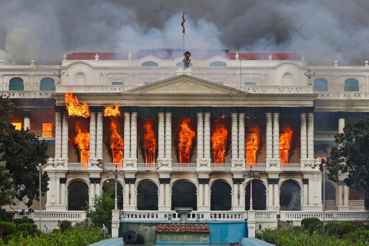 El fuego arrasa Singha Durbar, el principal edificio administrativo del gobierno de Nepal, en Katmandú el 9 de septiembre de 2025, un día después de una represión policial contra las manifestaciones por la prohibición de las redes sociales y la corrupción por parte del gobierno. Jóvenes manifestantes nepalíes prendieron fuego al parlamento el 9 de septiembre mientras el veterano primer ministro obedecía a multitudes furiosas para renunciar, un día después de una de las represiones más mortíferas en años en la que murieron al menos 19 personas. (Foto de Prabin RANABHAT / AFP)