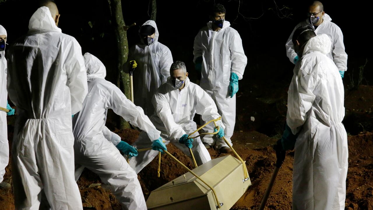 Los trabajadores del cementerio bajan el ataúd de una víctima de covid-19 a su tumba en el cementerio de Vila Formosa en Sao Paulo, Brasil. (AP Photo/Nelson Antoine)