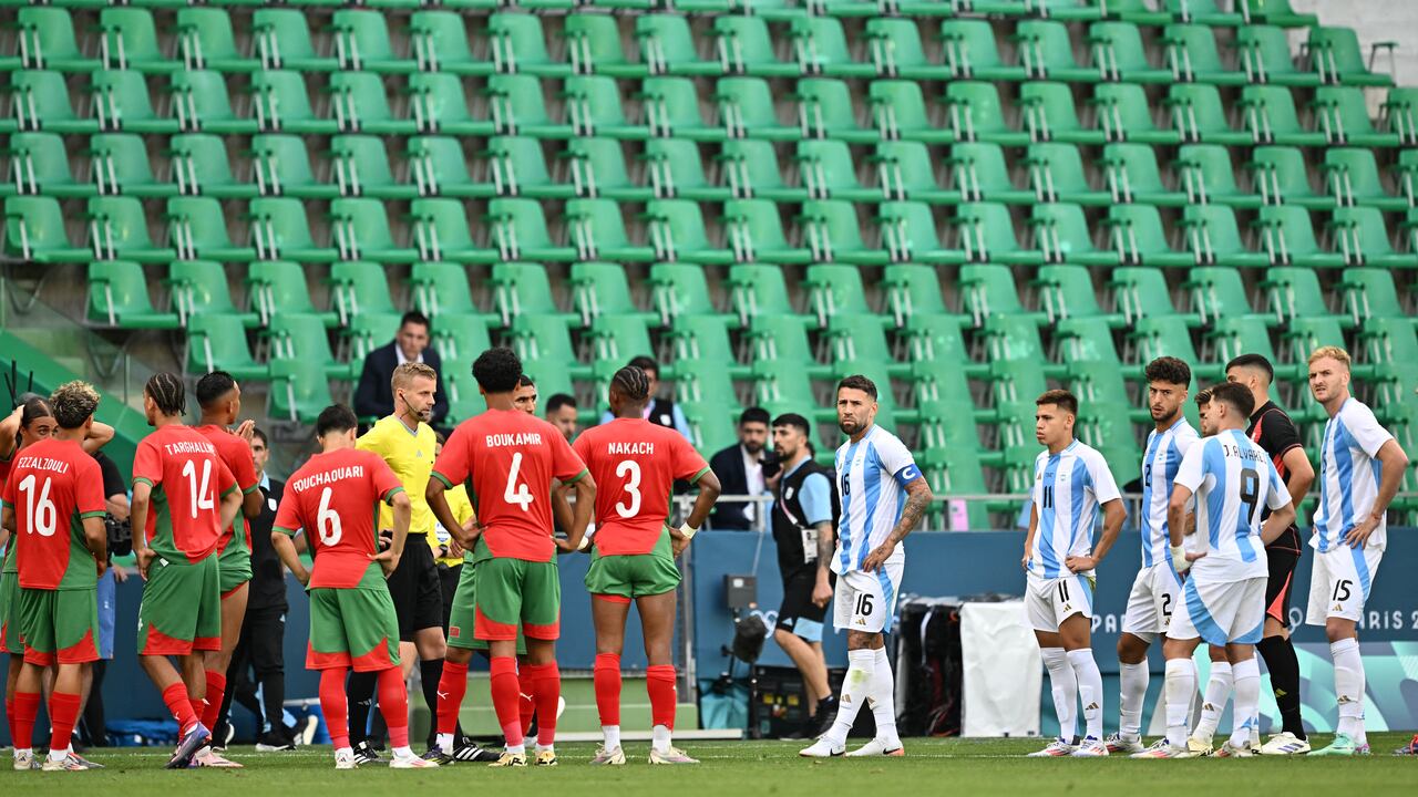 El árbitro sueco Glenn Nyberg observa cómo los jugadores de Argentina y Marruecos se preparan para comenzar a jugar nuevamente, en un estadio vacío luego de incidentes, una interrupción de dos horas y la cancelación del gol del empate de Argentina. (Foto Arnaud FINISTRE / AFP)