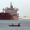 En esta fotografía de archivo del 12 de agosto de 2014, pescadores egipcios pescan frente a un barco maltés que cruza el Canal de Suez en Ismailia, Egipto. Un enorme carguero se ha volcado de lado en el Canal de Suez de Egipto, bloqueando el tráfico en una vía fluvial crucial Este-Oeste para el transporte marítimo global, según datos satelitales a los que se tuvo acceso el miércoles 24 de marzo de 2021. Foto / Amr Nabil.