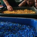 Trozos diminutos de plástico reciclado en contenedores en un centro de gestión de basura en Ghana. Son fichas de colores en contenedores de basura gigantes, en un centro de reciclaje.