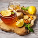 Taza de té de cúrcuma de jengibre sobre tabla de madera con ingredientes. Fondo rústico. Comida de invierno saludable