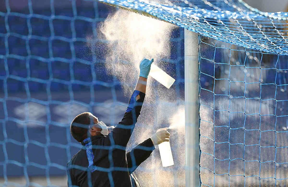 El fútbol vuelve poco a poco. Un hombre limpia el travesaño de una de las porterías, en el partido de la Premier League entre Everton y Liverpool, en Goodison Park, Liverpool, Inglaterra, el 21 de junio. Foto: Shaun Botterill, Pool/ AP