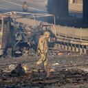 Un soldado ucraniano se desplaza entre los restos de un camión militar incendiado en una calle en Kiev, Ucrania, el sábado 26 de febrero de 2022. (AP Foto/Efrem Lukatsky)