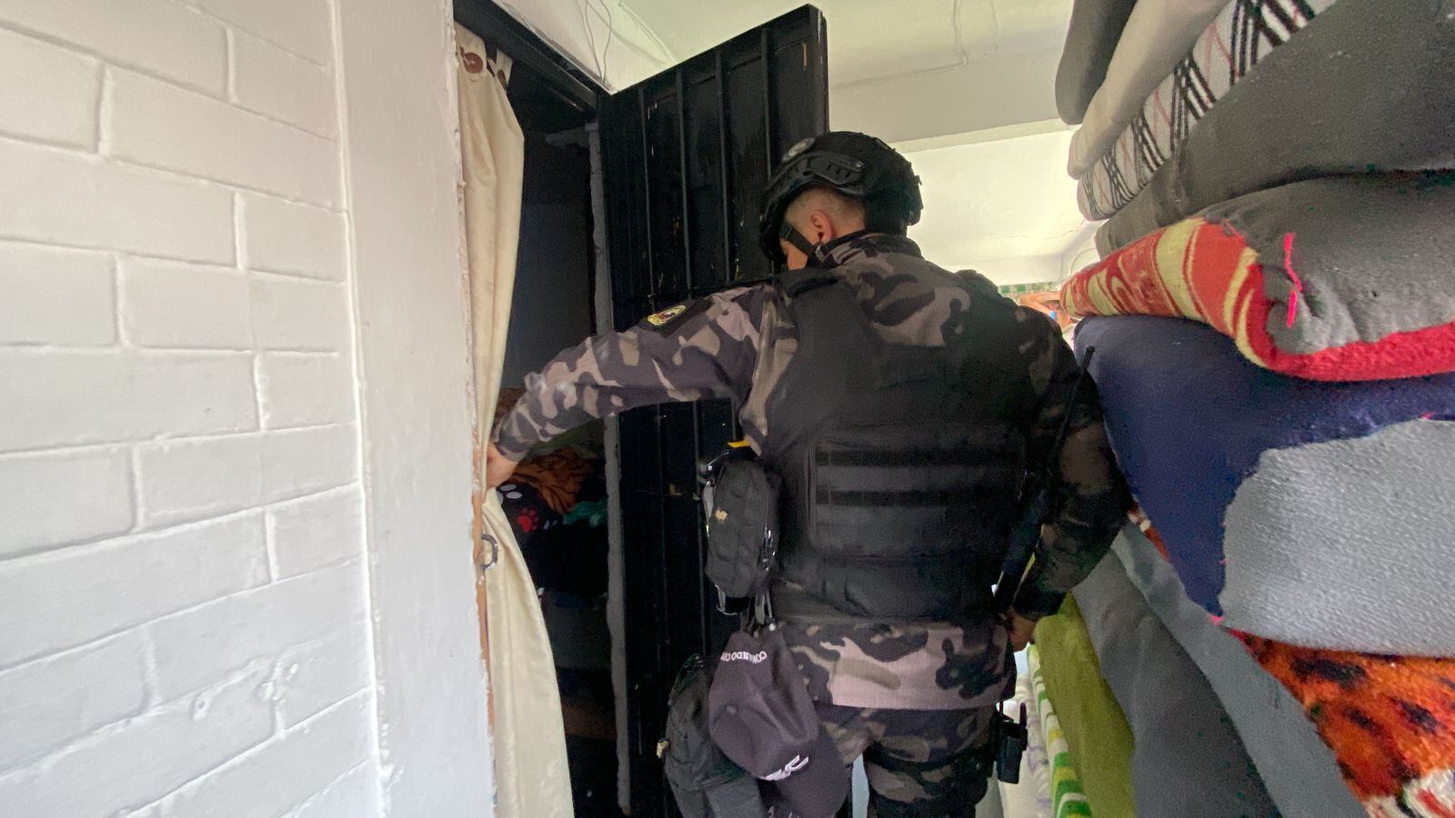 Integrante del Inpec inspecciona celdas de reclusos en redada contra la extorsión.