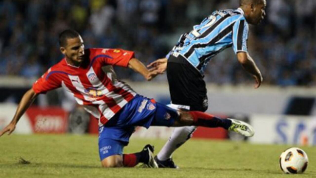 El jugador Gabriel del Gremio de Porto Alegre disputa el balón con Cesar Fawcett del Junior de Barranquilla (COL), durante el partido de la fase de grupos de la Copa Libertadores de América que les enfrentó en el estadio Olímpico de Porto Alegre, sur de Brasil.
