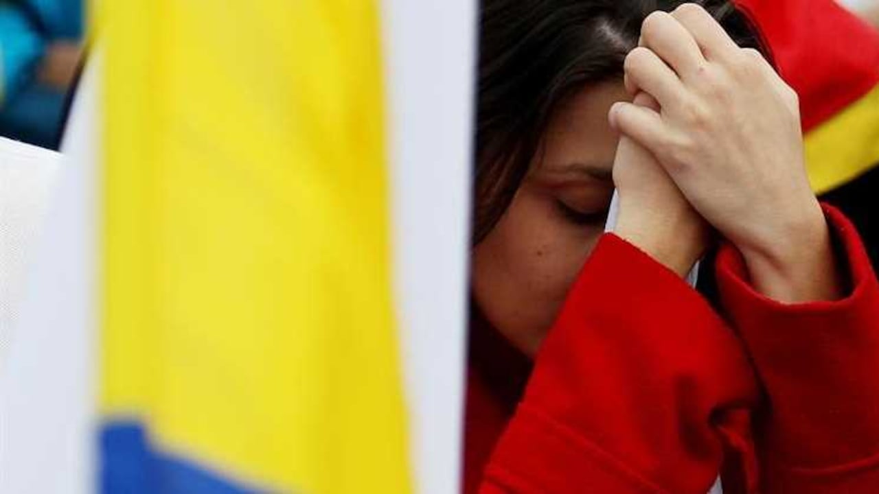 Colombianos reaccionan tras escuchar los resultados del plebiscito este domingo, 2 de octubre de 2016, en Bogotá. Con el 99,08% de las mesas contabilizadas, el "no" al acuerdo de paz obtenía 6.400.516 votos, que equivalen al 50,24% del total, mientras el "sí", que comenzó liderando el recuento alcanzaba 6.338.473 papeletas, que representan el 49,75 %, lo que supone una ventaja de 62.043 sufragios. EFE
