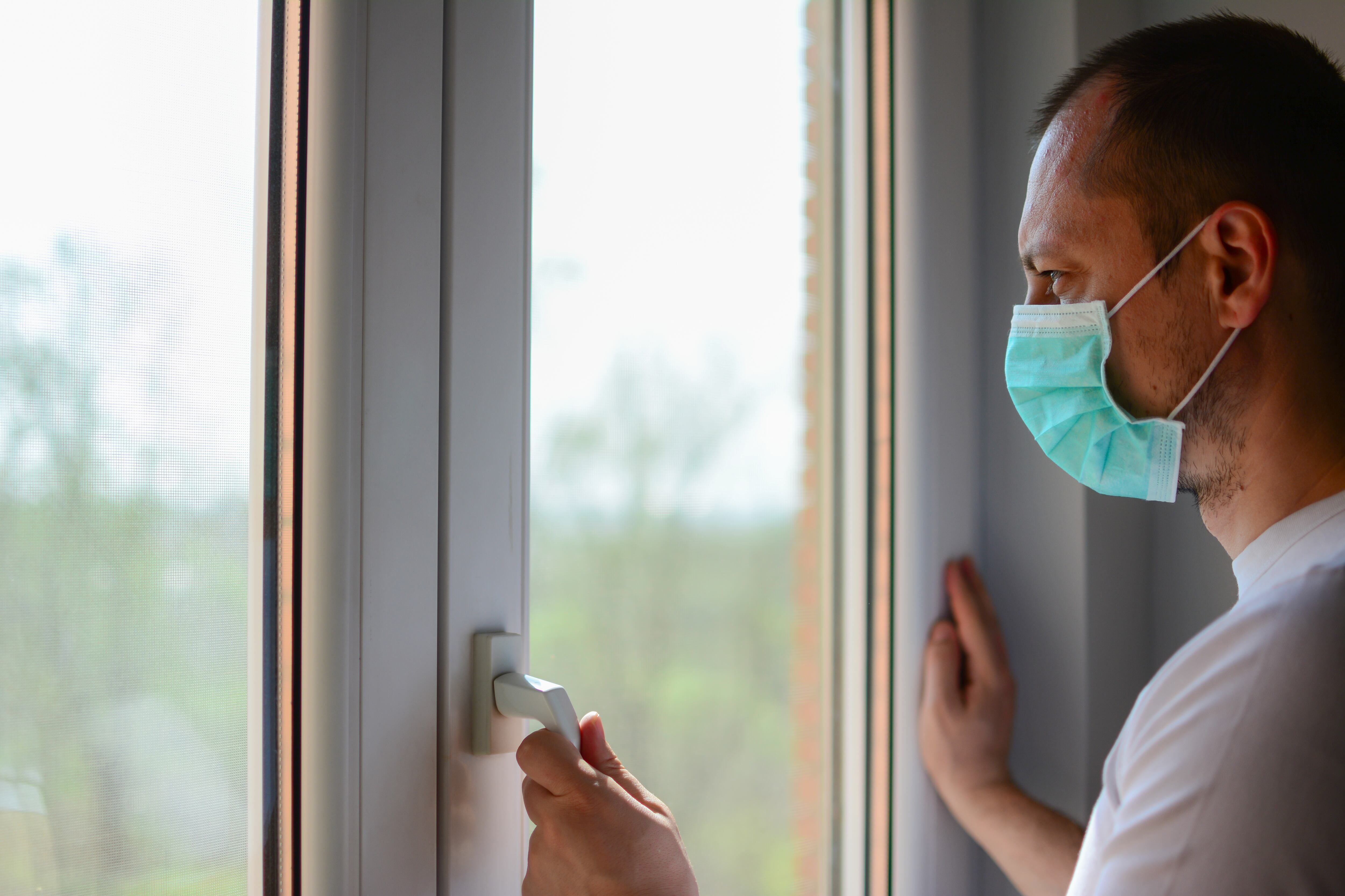 COVID-19 Pandémica de coronavirus Hombre aislamiento en el hogar cuarentena automática con máscara facial protectora para la propagación del virus de la enfermedad SARS-CoV-2. Máscara de aislamiento masculino en la cara contra la enfermedad del coronavirus 2020.