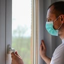 COVID-19 Pandémica de coronavirus Hombre aislamiento en el hogar cuarentena automática con máscara facial protectora para la propagación del virus de la enfermedad SARS-CoV-2. Máscara de aislamiento masculino en la cara contra la enfermedad del coronavirus 2020.