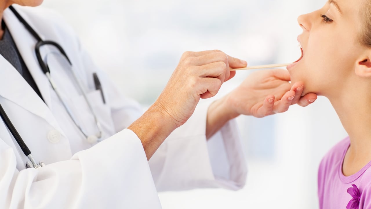 Médico revisando las amígdalas