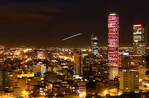 "looking at downtown bogota, colombia and its torre colpatria (on of latin americas talles buildings) that is illuminated in different colors, see more colors in my portfolioNotice the plane taking off in the center of the frame!"