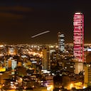 "looking at downtown bogota, colombia and its torre colpatria (on of latin americas talles buildings) that is illuminated in different colors, see more colors in my portfolioNotice the plane taking off in the center of the frame!"