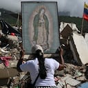 Una mujer sostiene una imagen de la Virgen de Guadalupe mientras voluntarios y familiares de las víctimas buscan los cuerpos de sus seres queridos entre los escombros de un edificio destruido por los terremotos del 24 de junio en Caraballeda, Venezuela, el 17 de julio de 2026.