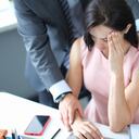 Empresario molestando a una colega en el lugar de trabajo. Concepto de acoso en el trabajo