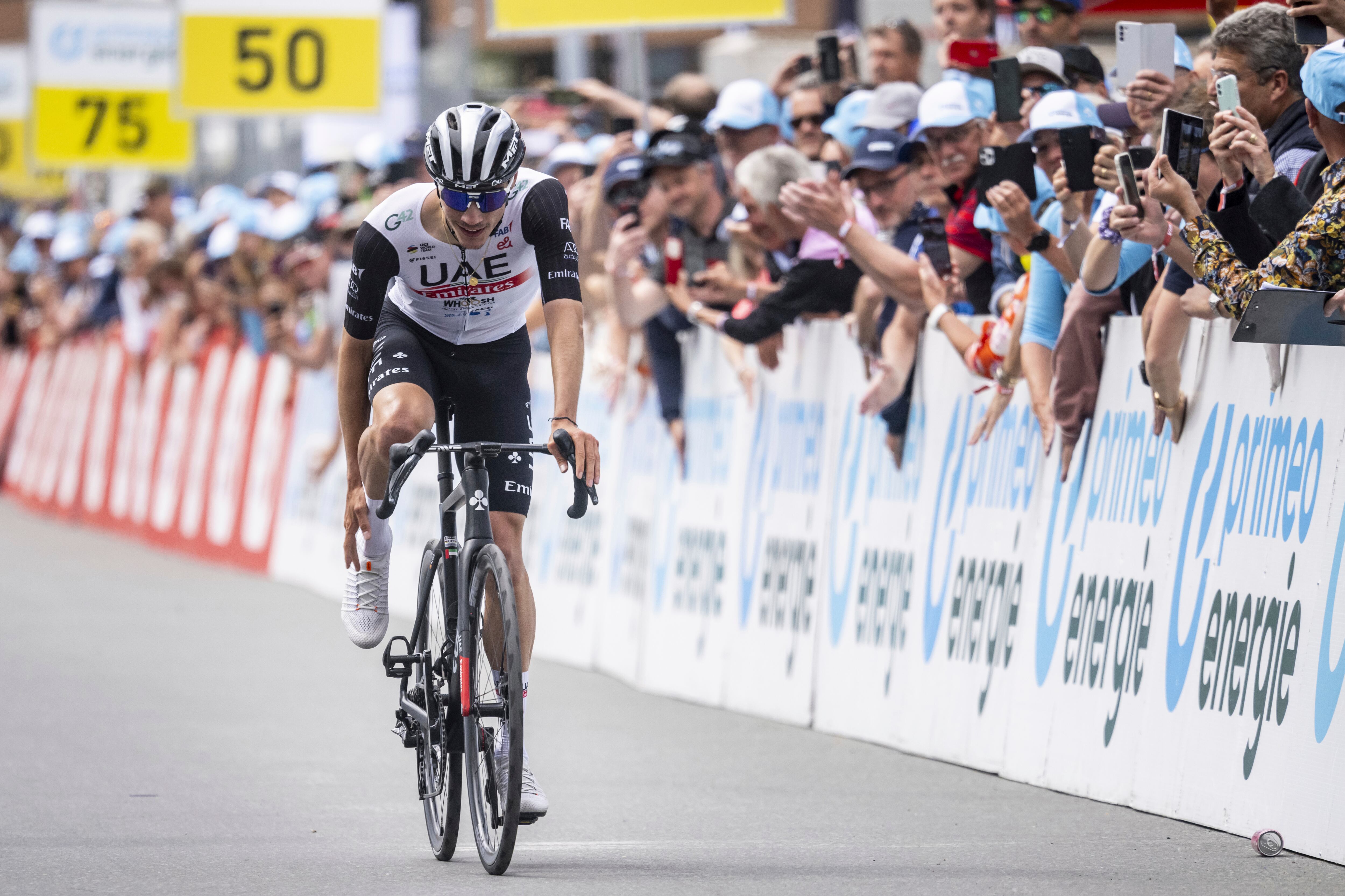 Juan Ayuso from Spain of UAE Team Emirates celebrates crossing the finish line as the winner of the fifth stage, a 211 km race from Fiesch to La Punt, of the 86th Tour de Suisse UCI World Tour cycling race in Goms, Switzerland, Thursday, June 15, 2023. (Gian Ehrenzeller/Keystone via AP)