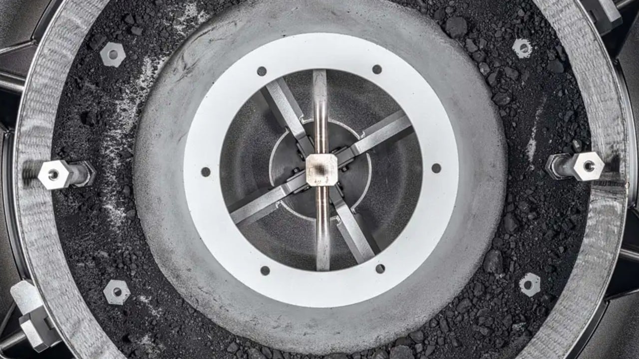 Una vista superior del mecanismo TAGSAM de OSIRIS-REx mostró el interior de la muestra del asteroide Bennu con polvo y rocas.