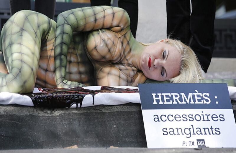 La presentadora belga de televisión Lesley Ann posa con el cuerpo pintado como la piel de cocodrilo junto a activistas de los colectivos Peta y Gaia. La protesta es parte de una campaña de Peta contra la firma de lujo francesa Hermés. 