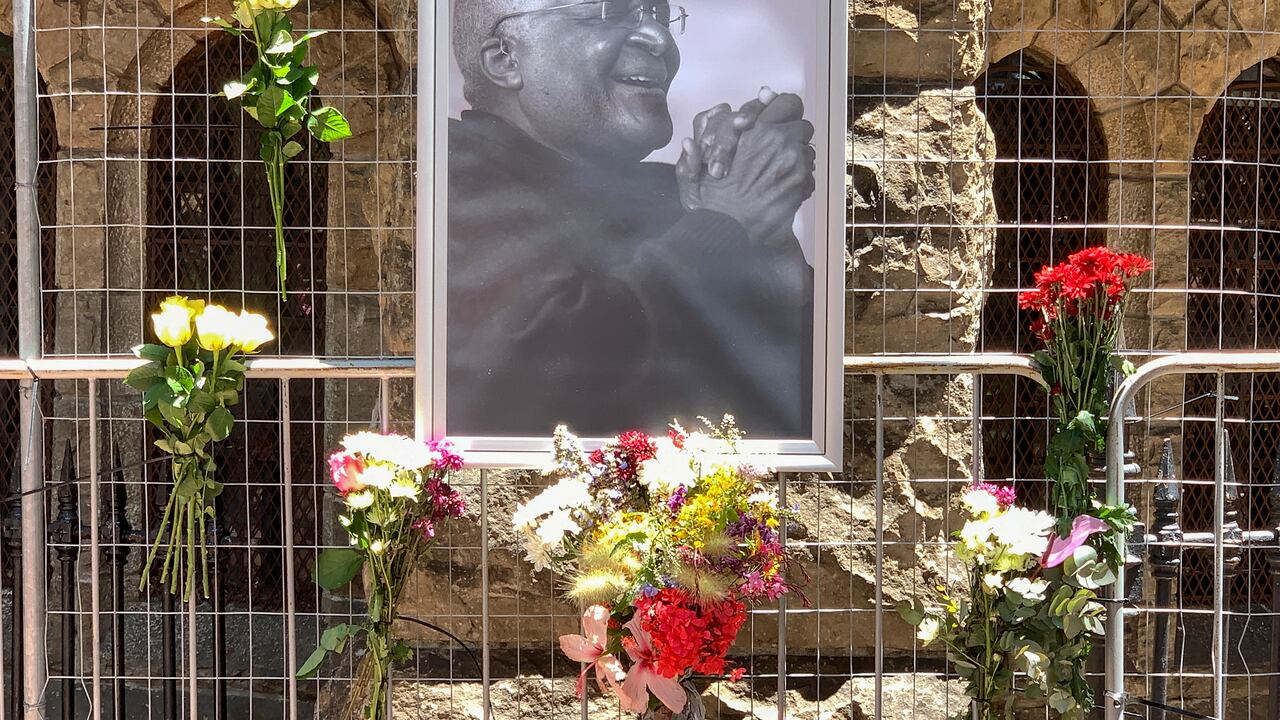 Flores junto a un retrato del ícono sudafricano anti-apartheid Desmond Tutu afuera de la catedral de San Jorge en Ciudad del Cabo el 26 de diciembre de 2021, luego de la noticia del fallecimiento de Tutu. - El ícono sudafricano anti-apartheid Desmond Tutu, descrito como la brújula moral del país, murió el 26 de diciembre de 2021, a los 90 años.(Photo by Gianluigi GUERCIA / AFP)