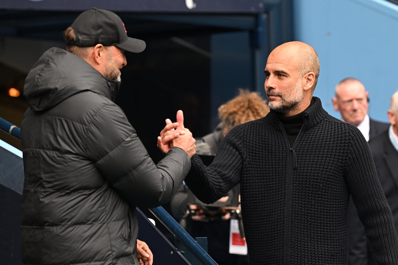El técnico alemán del Liverpool, Jurgen Klopp (i), y el técnico español del Manchester City, Pep Guardiola (derecha), se dan la mano antes del inicio del partido de fútbol de la Premier League inglesa entre Manchester City y Liverpool en el estadio Etihad de Manchester, al noroeste de Inglaterra, en abril. 1, 2023.
