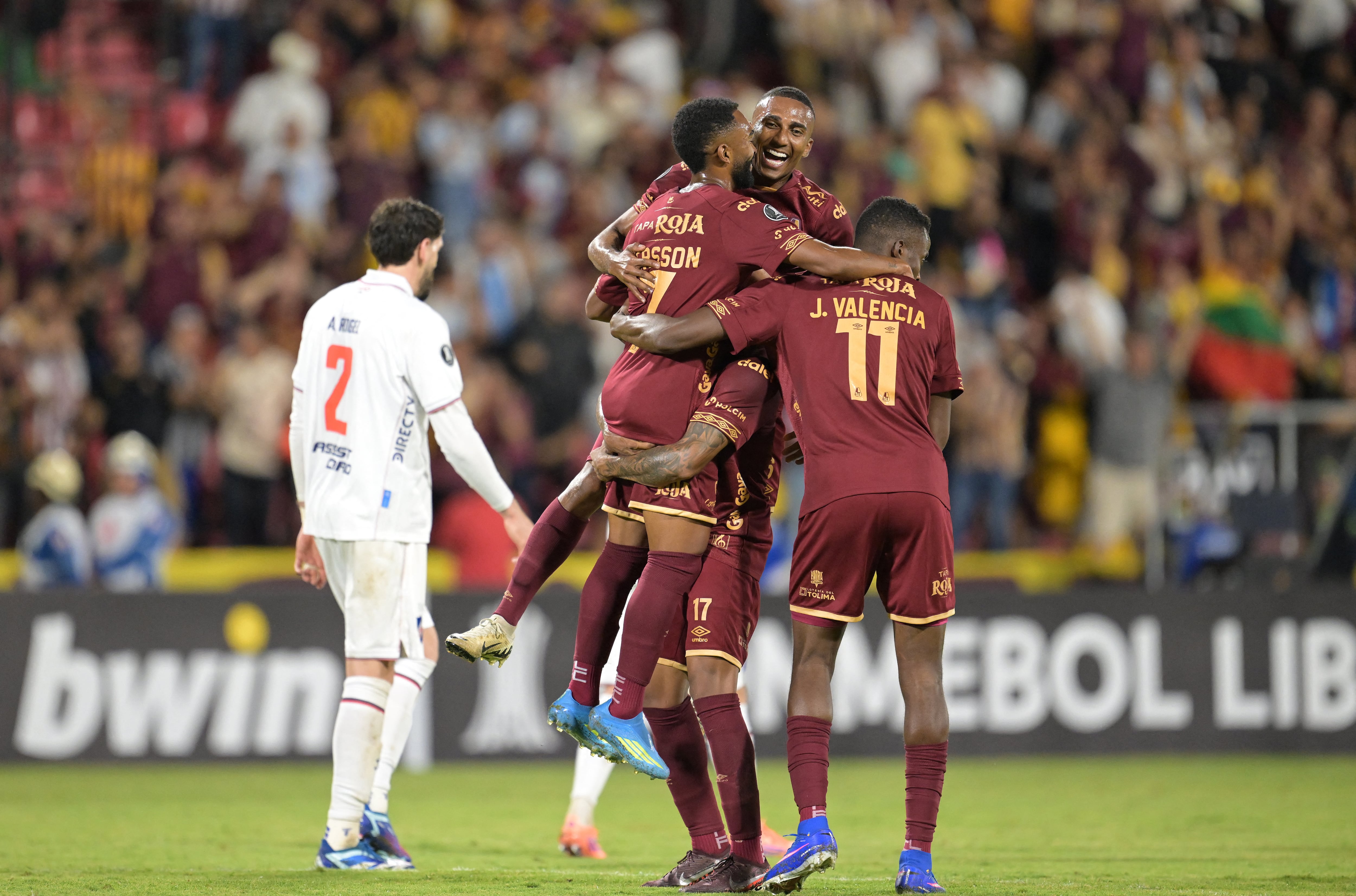 Tolima's forward #07 Jersson Gonzalez (L) celebrates with teammates after scoring his team's third goal during the Copa Libertadores group stage football match between Colombia's Deportes Tolima and Uruguay's Nacional at the Manuel Murillo Toro stadium in Ibague, Colombia on May 6, 2026. (Photo by Raul ARBOLEDA / AFP)