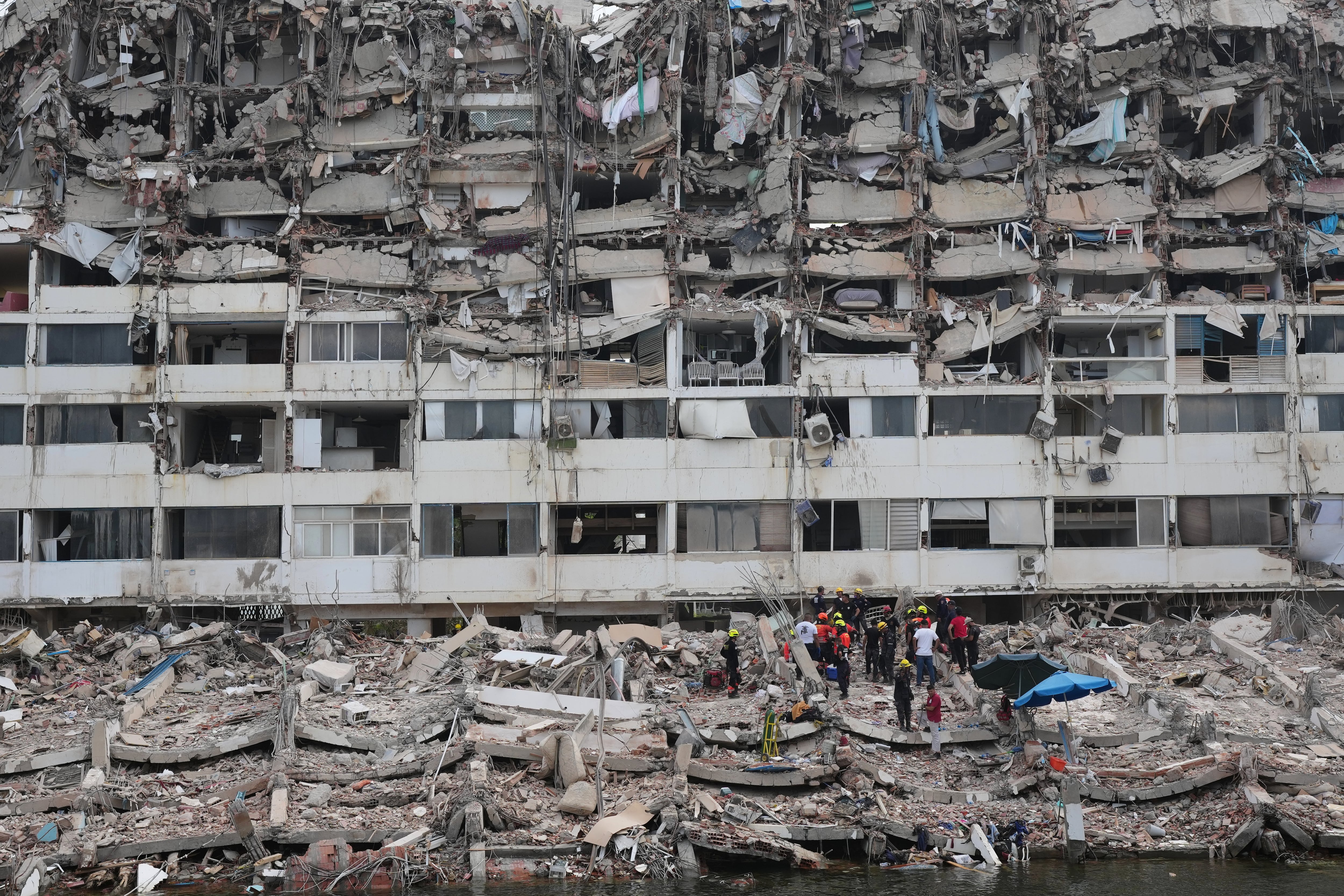 Equipos de rescate buscan entre los escombros de un edificio que colapsó cuando se produjeron terremotos en La Guaira, Venezuela.