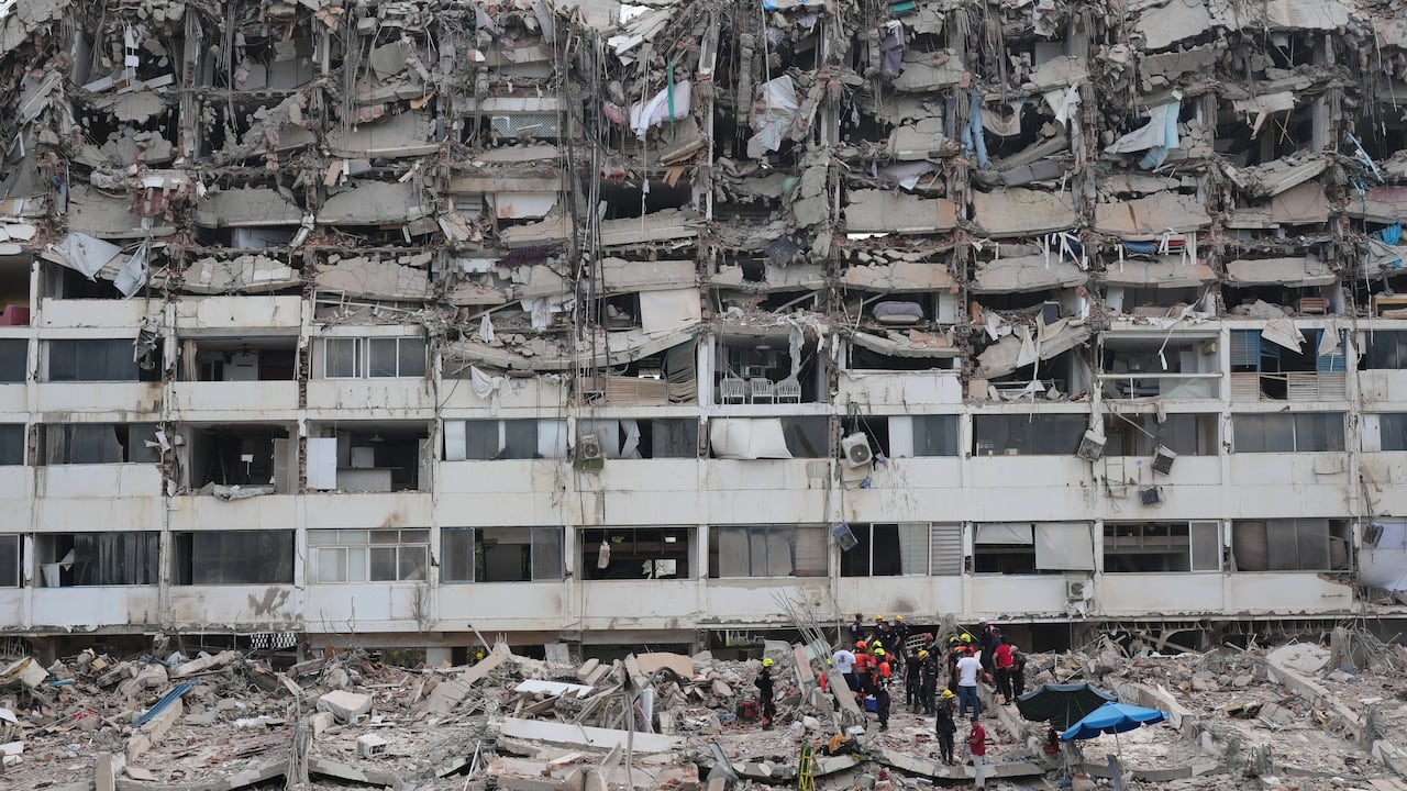 Equipos de rescate buscan entre los escombros de un edificio que colapsó cuando se produjeron terremotos en La Guaira, Venezuela.