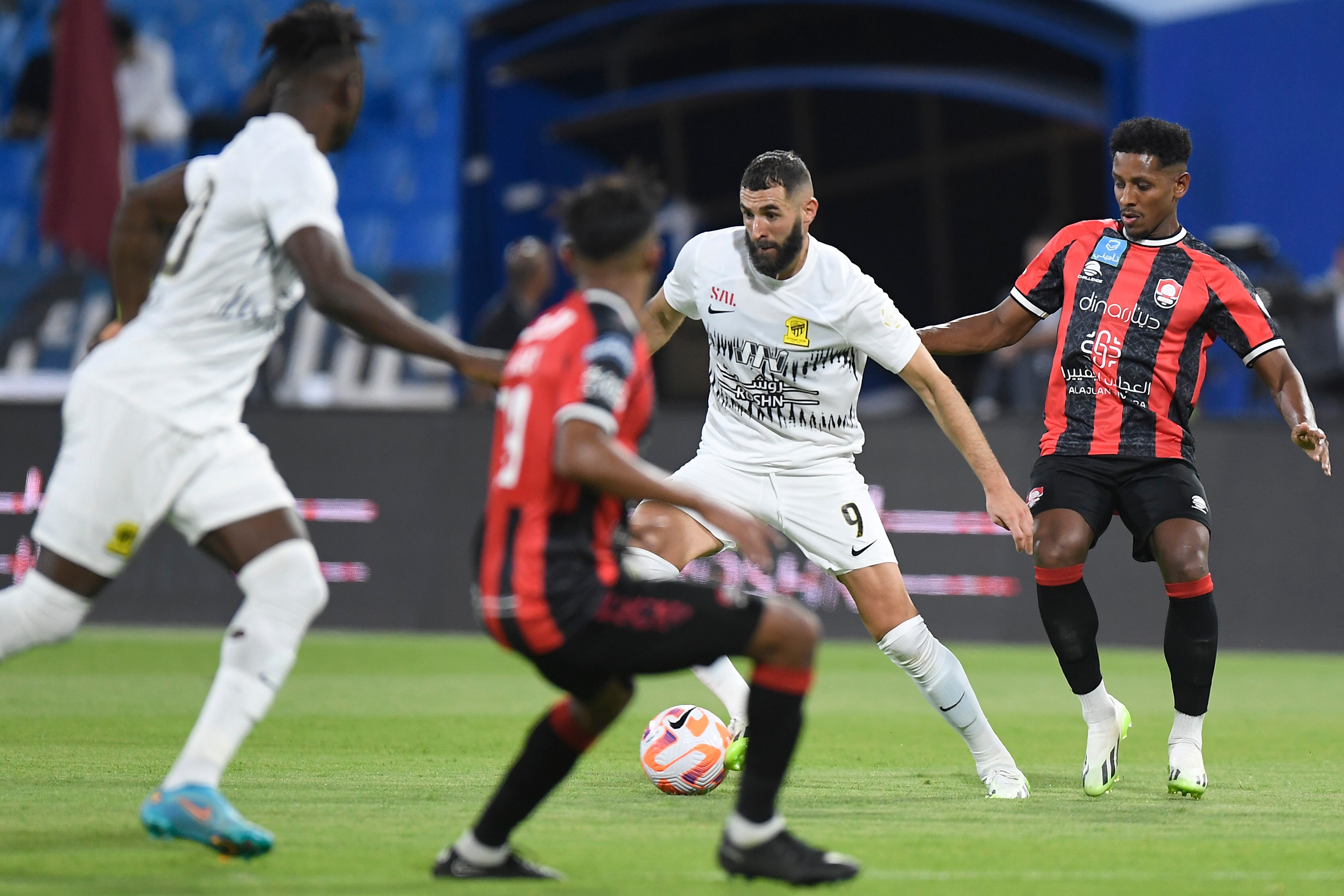 Al Ittihad's Karim Benzema, center right, fights for the ball during his team match against Al Raed in Saudi Professional League, in Buraidah, Saudi Arabia, Monday, Aug. 14, 2023. (AP Photo)