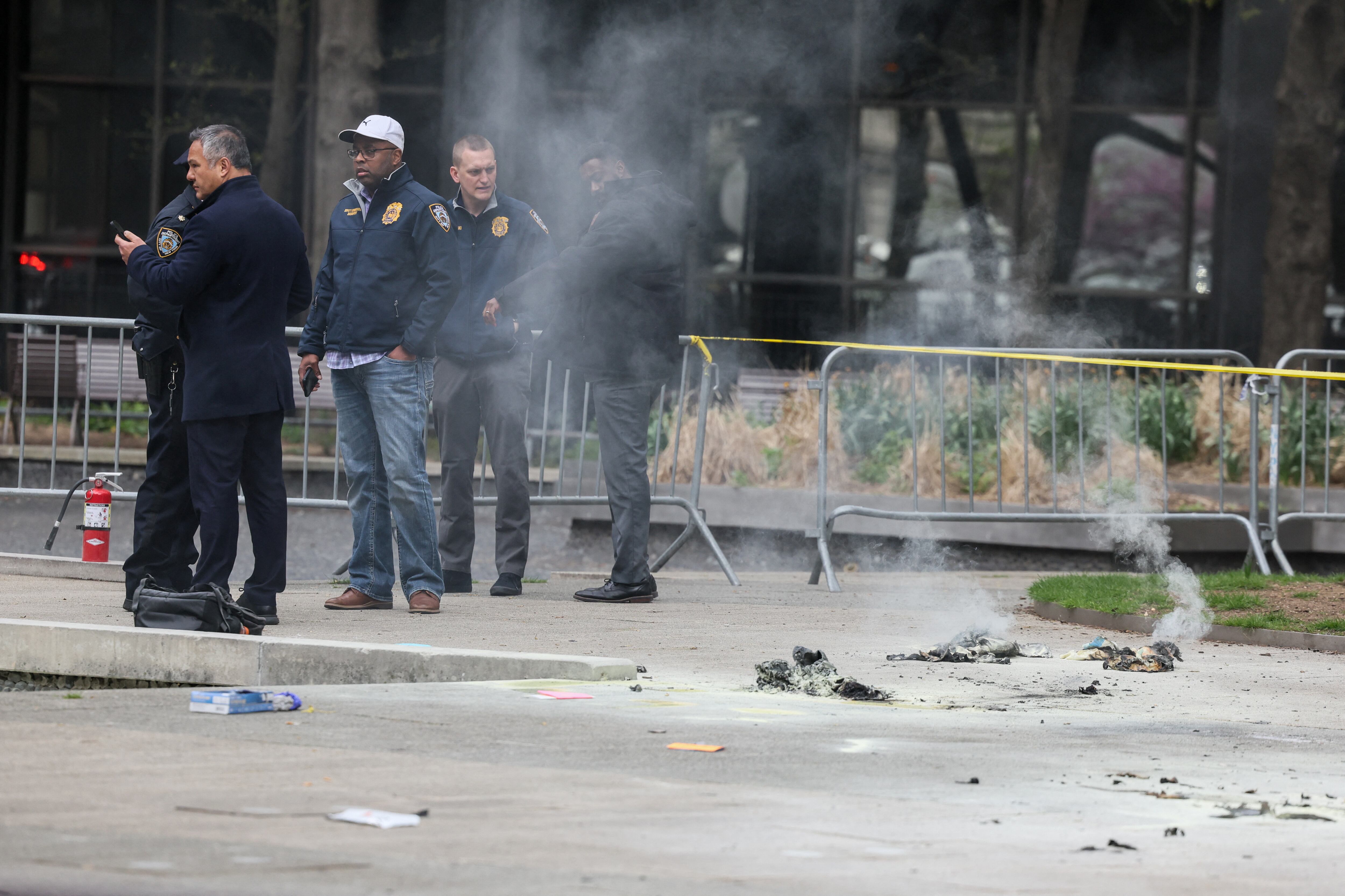 El personal de emergencia trabaja en el lugar donde una persona fue cubierta en llamas fuera del juzgado donde se lleva a cabo el juicio criminal por dinero secreto del ex presidente estadounidense Donald Trump, en Nueva York, EE.UU., el 19 de abril de 2024.