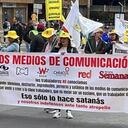 Manifestantes sostienen cartel en contra de varios medios de comunicación.