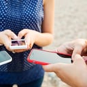 Cerca de tres personas que usan teléfonos inteligentes