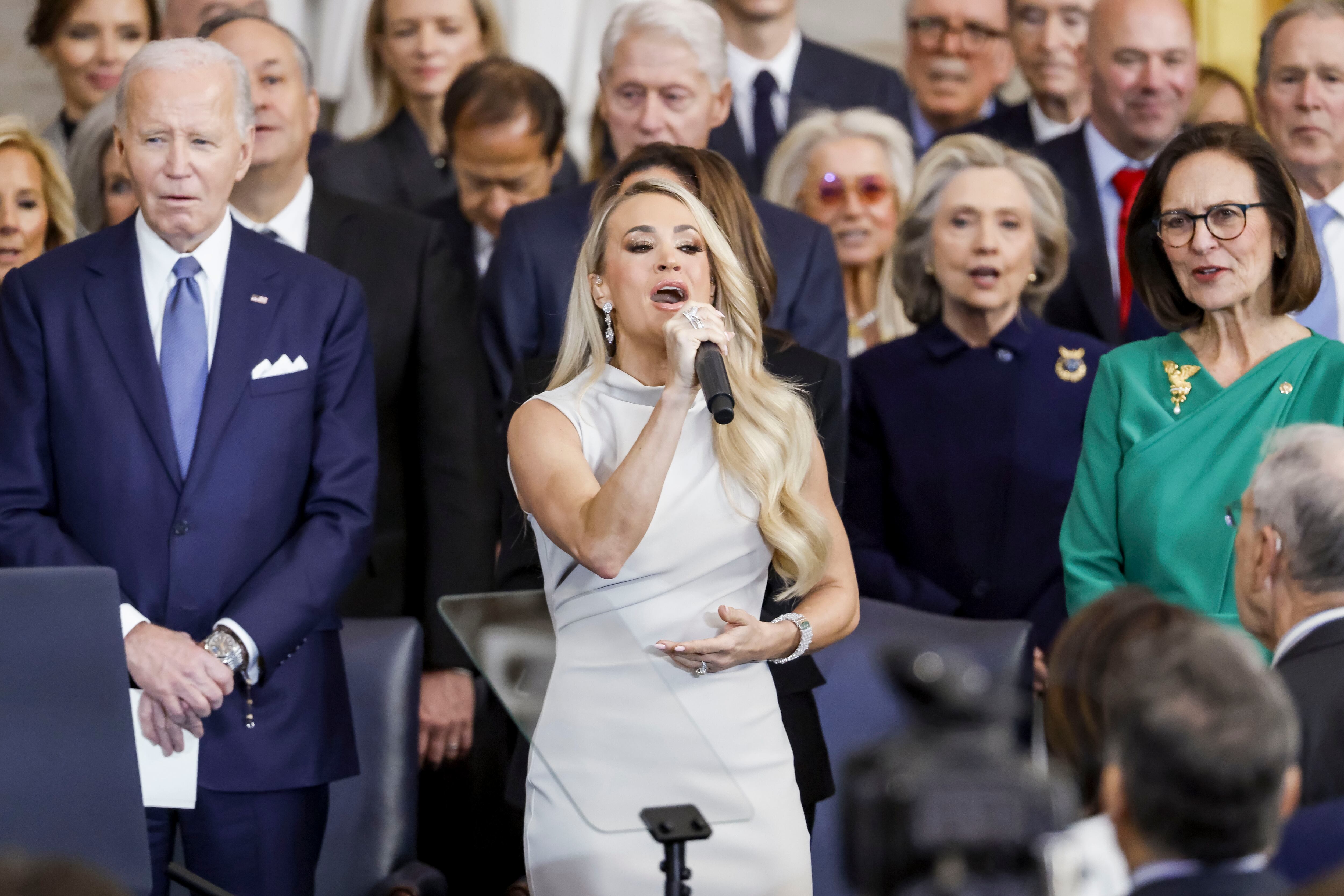 WASHINGTON, DC - JANUARY 20: Country singer Carrie Underwood (C) performs 'America the Beautiful' as former US President Joe Biden (L) looks on during US President Donald Trump's inauguration ceremony in the rotunda of the United States Capitol on January 20, 2025 in Washington, DC. Donald Trump takes office for his second term as the 47th President of the United States. (Photo by Shawn Thew-Pool/Getty Images)