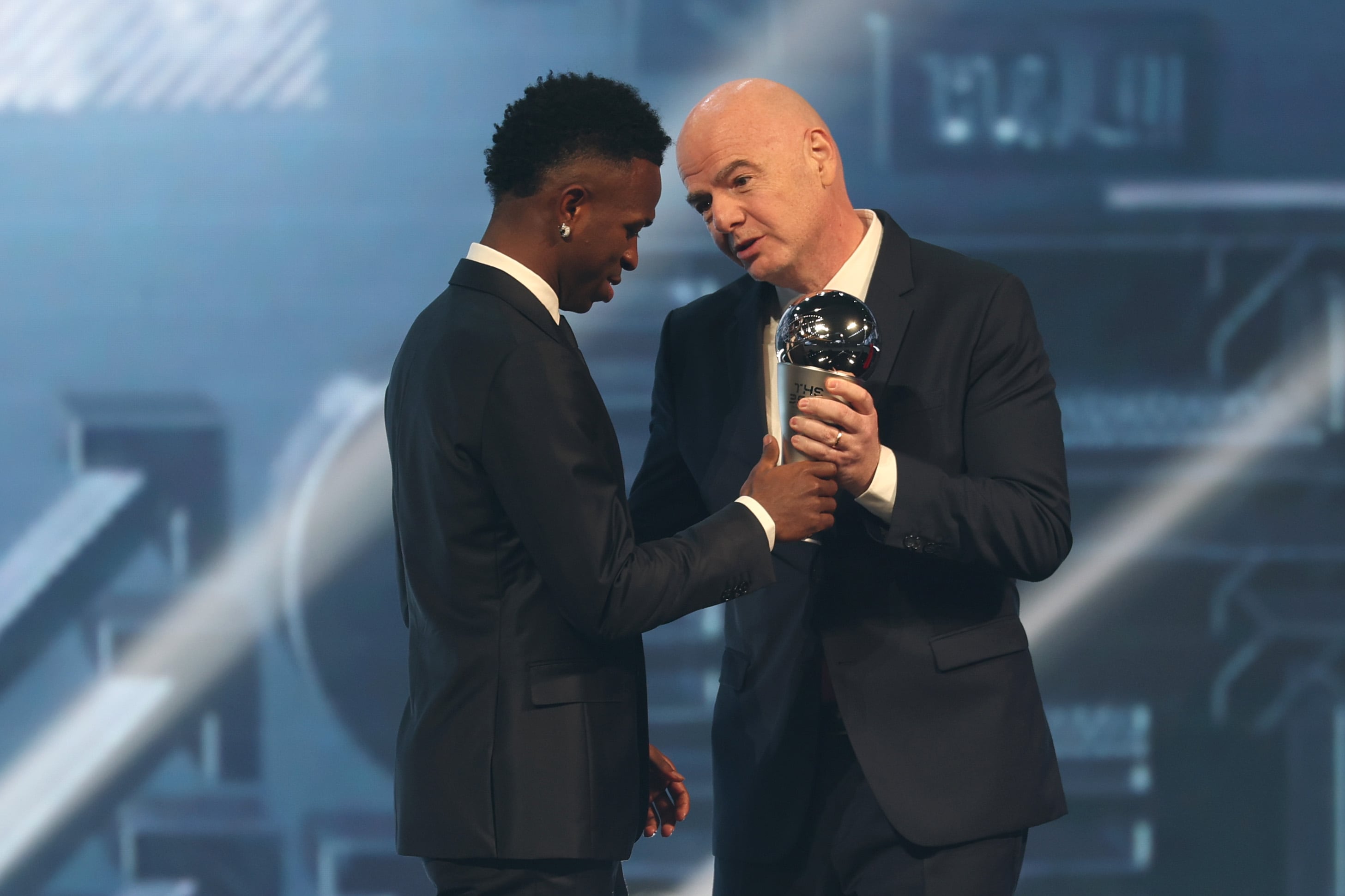 DOHA, QATAR - DECEMBER 17: Vinicius Junior of Real Madrid is presented with The Best FIFA Men's Player Award by Gianni Infantino, President of FIFA, during the The Best FIFA Football Awards 2024 at Aspire Academy on December 17, 2024 in Doha, Qatar. (Photo by Christopher Pike - FIFA/FIFA via Getty Images)