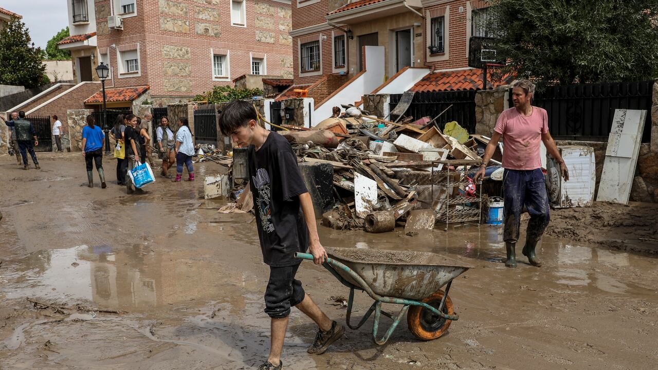 Los residentes ayudan a limpiar el barro y el agua de las casas luego de las fuertes lluvias el 4 de septiembre de 2023 en Villamanta, en la región de Madrid, España.