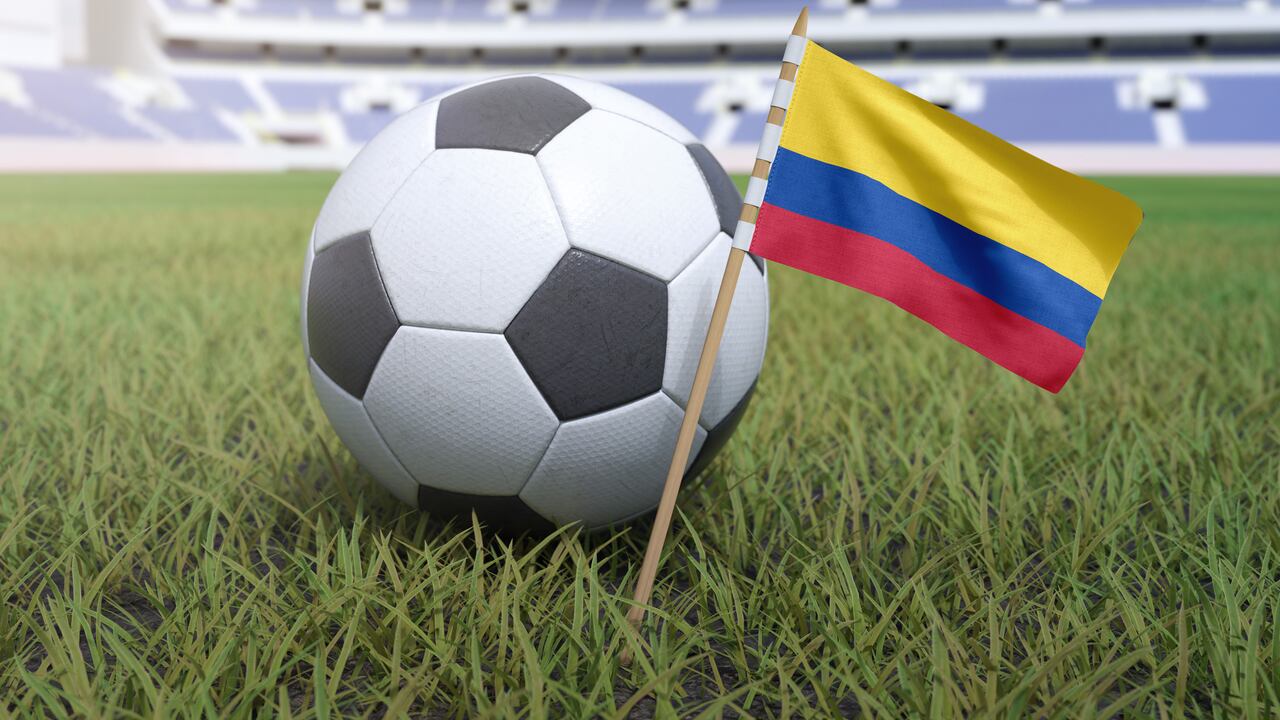 Bandera colombiana en el campo del estadio con fútbol soccer