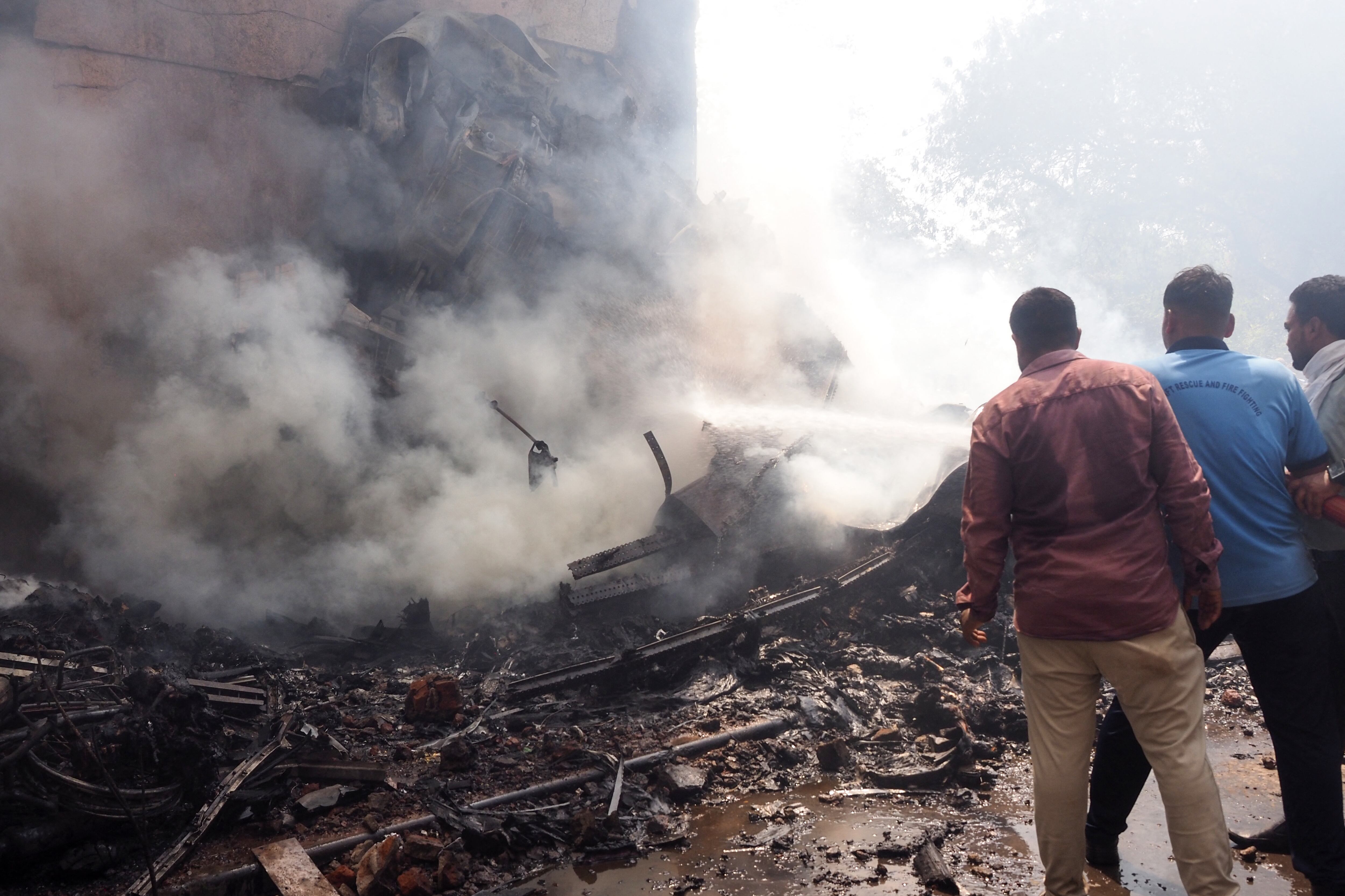 Los bomberos trabajan en el lugar donde se estrelló el vuelo 171 de Air India en una zona residencial cerca del aeropuerto de Ahmedabad el 12 de junio de 2025.