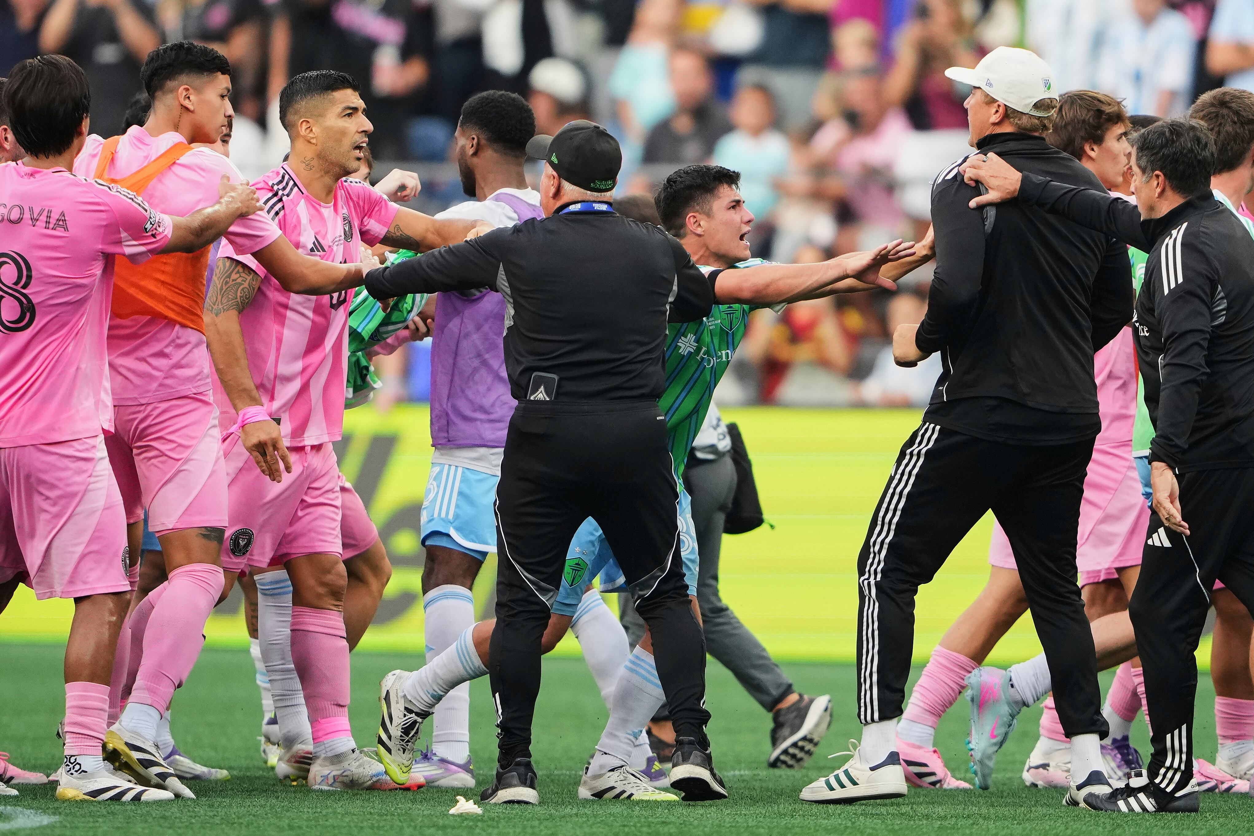 Inter Miami forward Luis Suárez, third from left, is separated from Seattle Sounders players and staff as Sounders midfielder Kalani Kossa-Rienzi, center right facing, holds a staff member back during a fight after the Sounders won the Leagues Cup final soccer match Sunday, Aug. 31, 2025, in Seattle. (AP Photo/Lindsey Wasson)