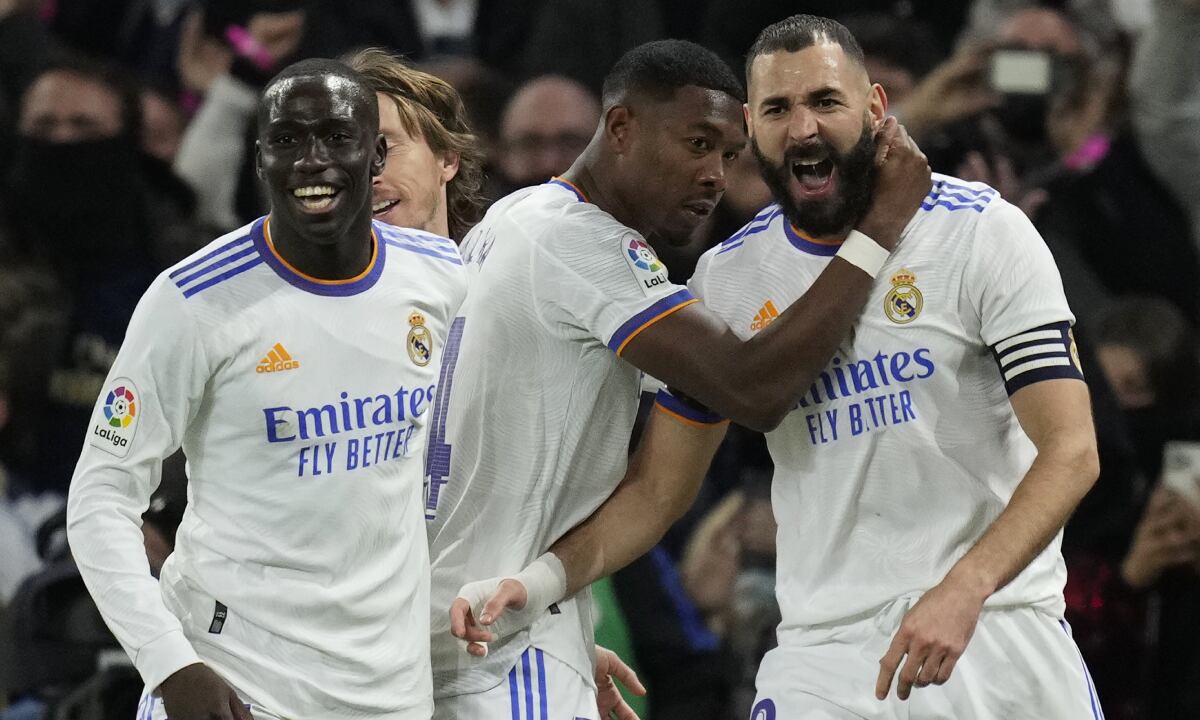 Karim Benzema (derecha) celebra tras anotar el primer gol en la victoria 2-0 ante el Atlético de Madrid, el domingo 12 de diciembre de 2021. (AP/Bernat Armangue)