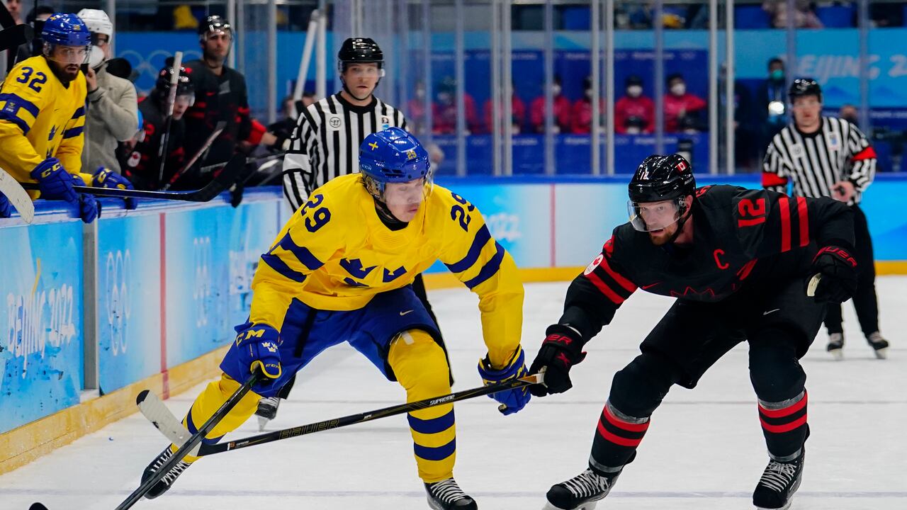 Sweden's Pontus Holmberg (29) chases the puck with Canada's Eric Staal (12) during a men's quarterfinal hockey game at the 2022 Winter Olympics, Wednesday, Feb. 16, 2022, in Beijing. (AP Photo/Matt Slocum)