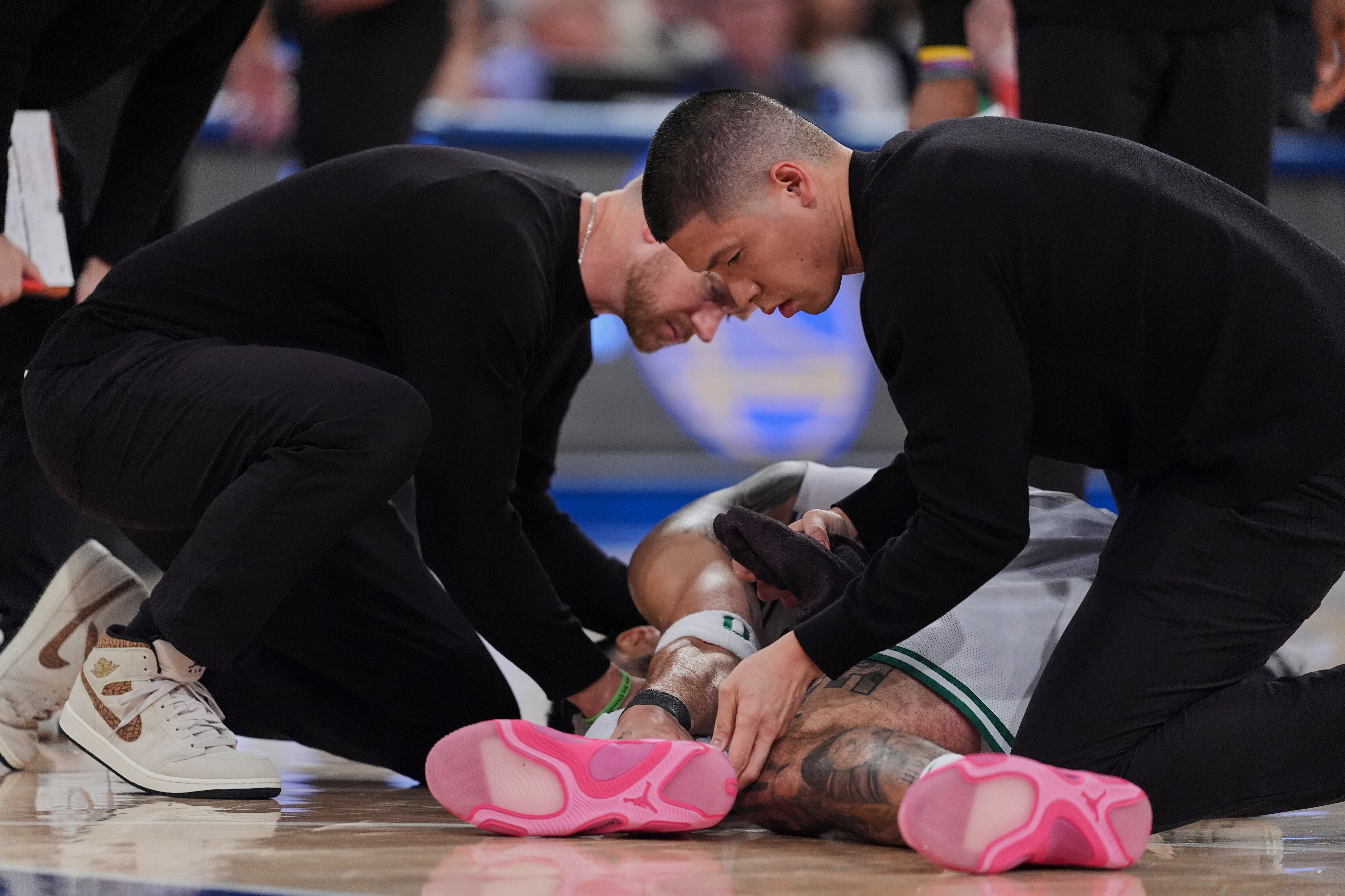 Trainers check on Boston Celtics' Jayson Tatum after he was injured during the second half of Game 4 in the Eastern Conference semifinals of the NBA basketball playoffs against the New York Knicks Monday, May 12, 2025, in New York. (AP Photo/Frank Franklin II)