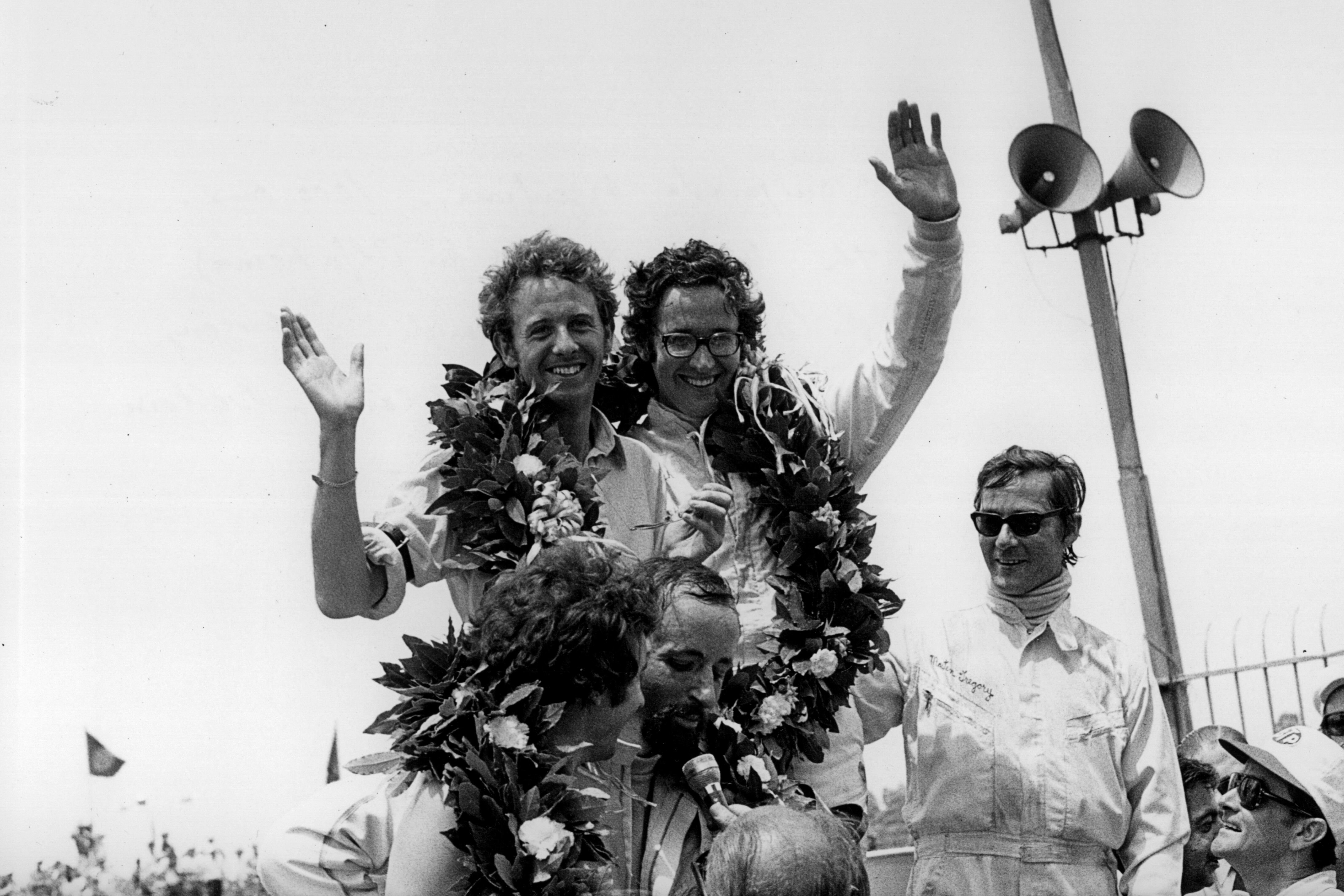 Andrea De Adamich (centro) celebra una victoria en su época como piloto.