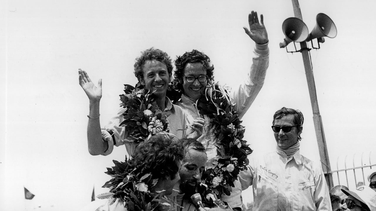 Andrea De Adamich (centro) celebra una victoria en su época como piloto.