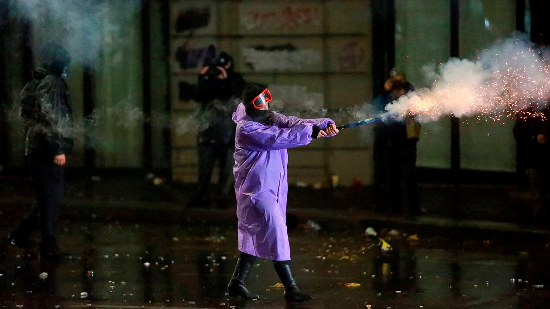 Un manifestante dispara un petardo hacia la Policía durante una protesta contra la decisión del Gobierno de suspender las negociaciones para unirse a la Unión Europea durante cuatro años