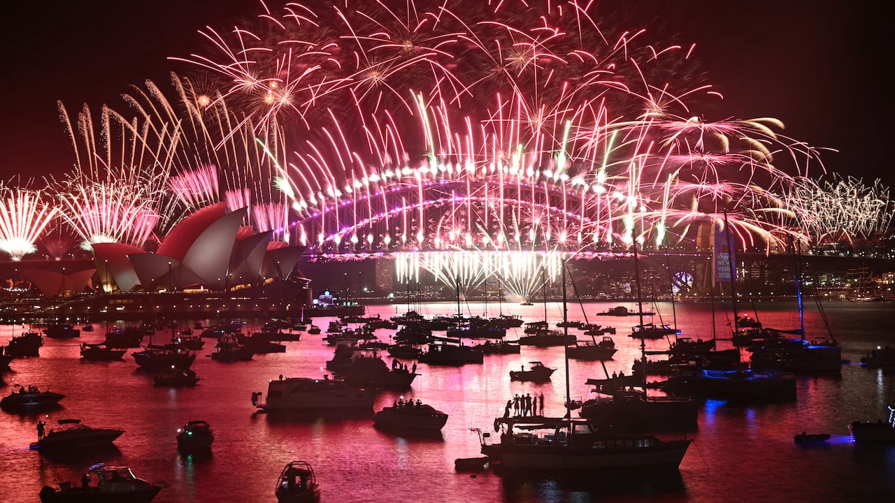 Los fuegos artificiales iluminan el cielo de medianoche sobre el Puente del Puerto de Sídney y la Ópera de Sídney durante las celebraciones del Día de Año Nuevo de 2025 en Sídney el 1 de enero de 2025. (Foto de Saeed KHAN / AFP)