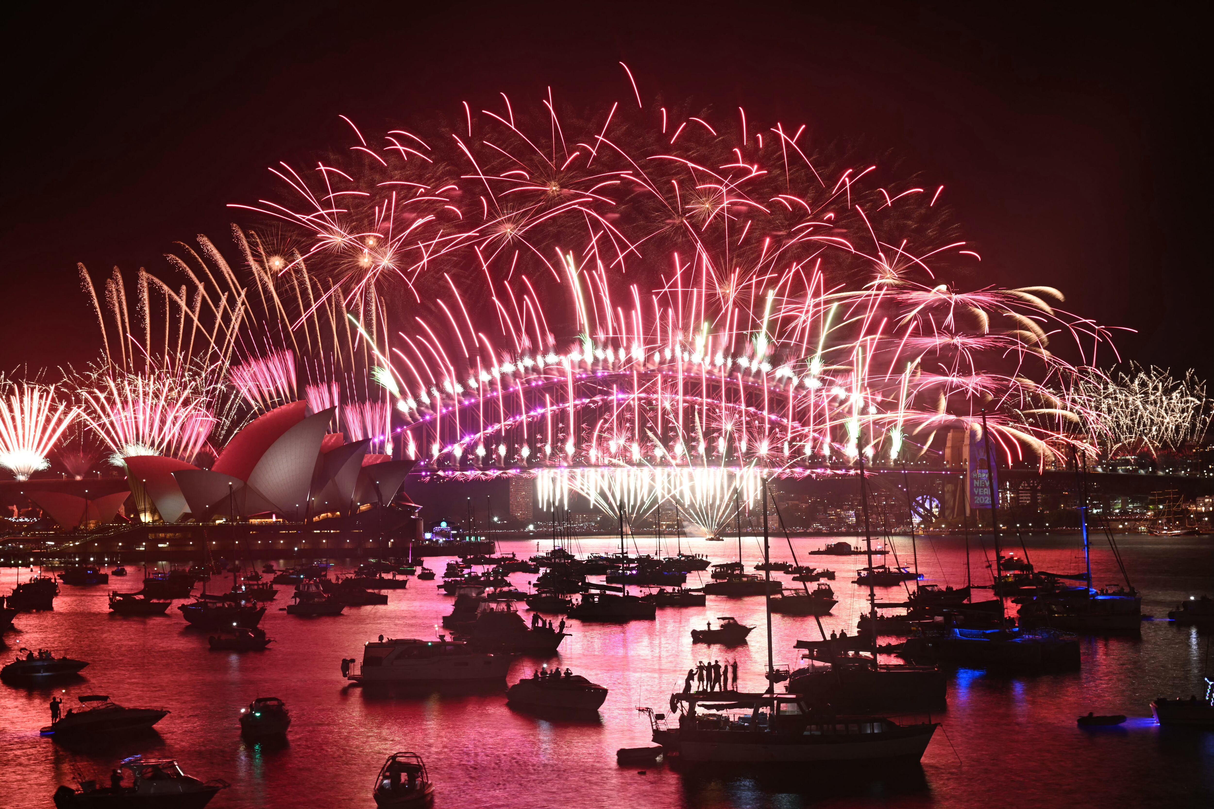 Los fuegos artificiales iluminan el cielo de medianoche sobre el Puente del Puerto de Sídney y la Ópera de Sídney durante las celebraciones del Día de Año Nuevo de 2025 en Sídney el 1 de enero de 2025. (Foto de Saeed KHAN / AFP)