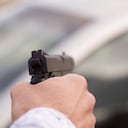 Una mano sosteniendo un arma robo atraco