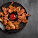Plate of barbecue chicken wings with sauce. Close up and top view