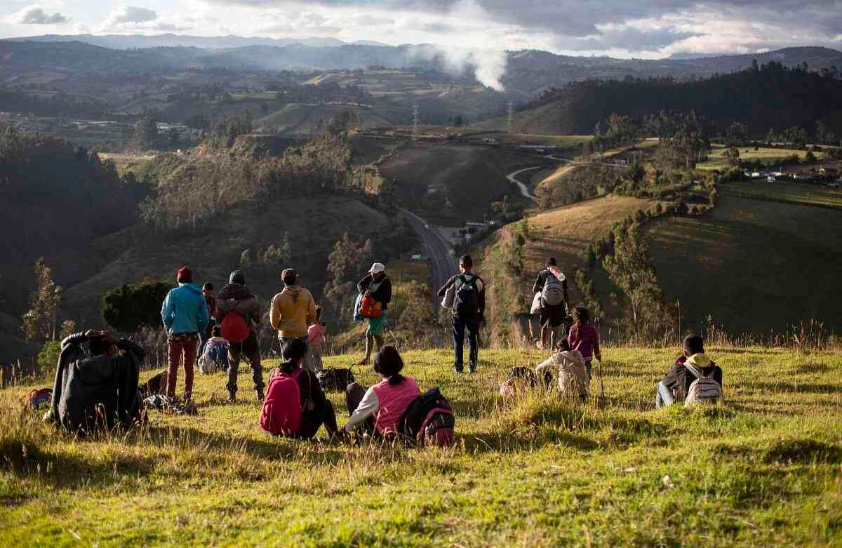Migrantes venezolanos miran desde una loma cubierta de hierba en la carretera Panamericana, en Urbina, Ecuador, el martes 27 de agosto de 2019. Los venezolanos que están varados en la frontera entre Colombia y Ecuador han comenzado a buscar alternativas para ingresar a Ecuador después de que el gobierno comenzó a exigir visas a los venezolanos para ingresar al país. (Foto AP / Edu León)